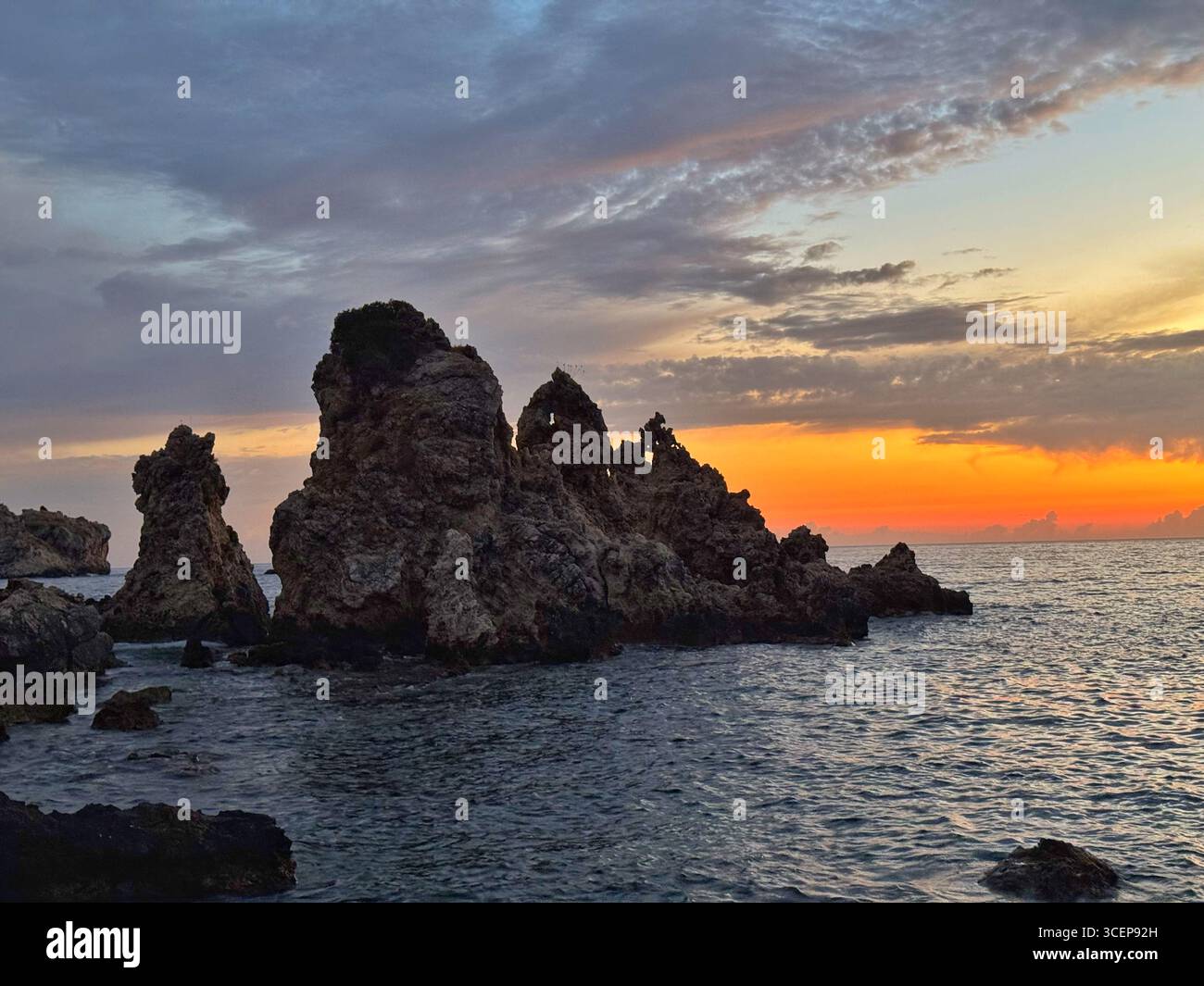 Jagged rocks at dusk on Agios Petros beach, Paleokastritsa, Corfu - Smartphone Captured Stock Image
