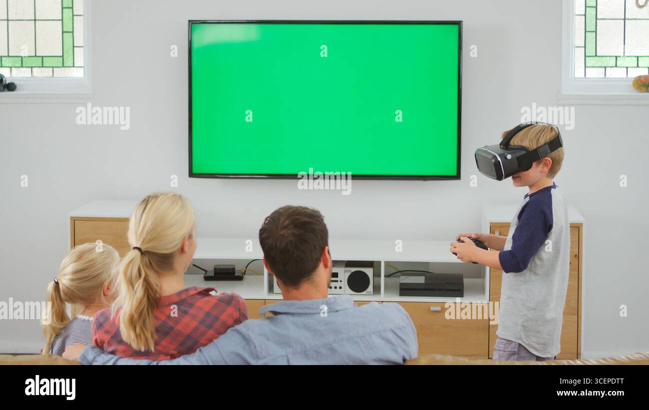 Family Playing Computer Game Using Virtual Reality Headset Stock Photo