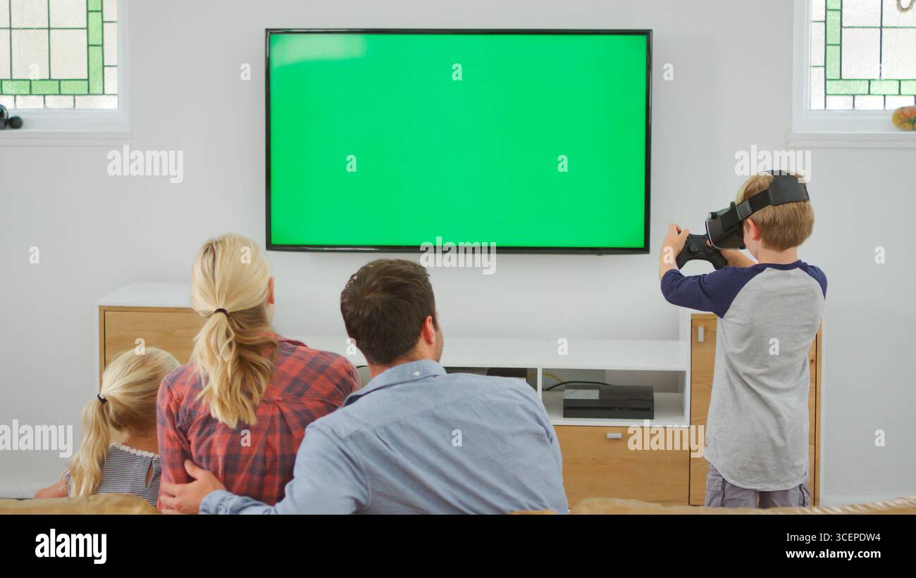 Family Playing Computer Game Using Virtual Reality Headset Stock Photo