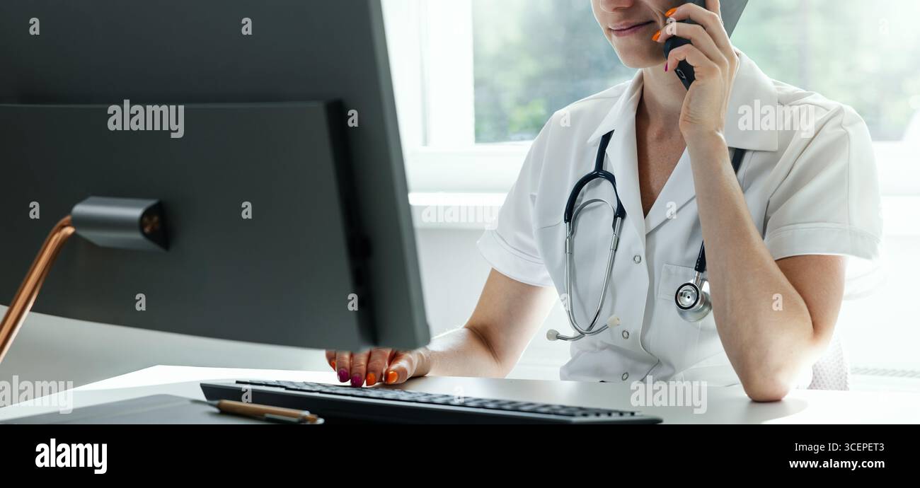 medical consultation, hospital helpdesk. doctor working on computer and talking on the phone in clinic office. copy space Stock Photo