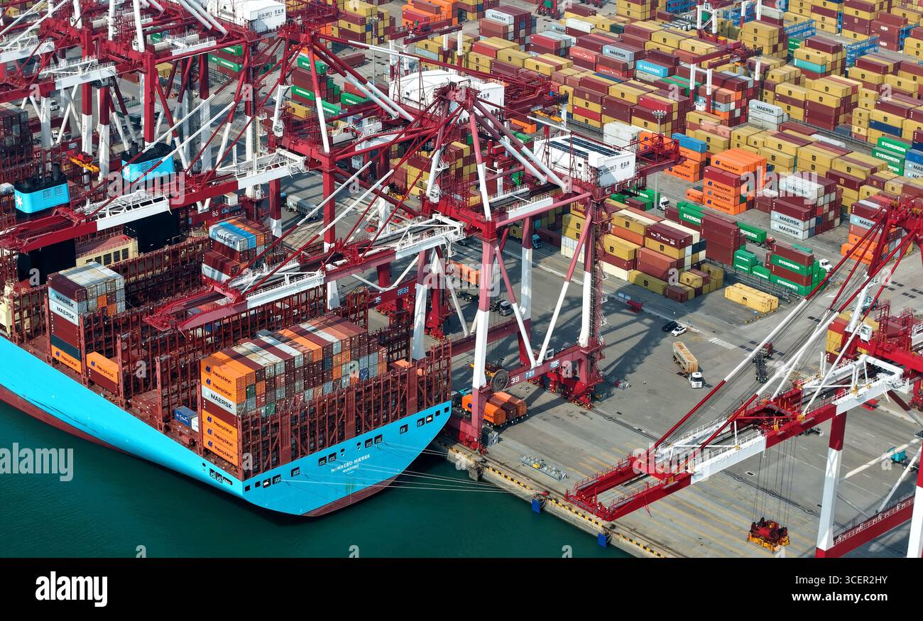 Qingdao. 19th Aug, 2025. An aerial drone photo taken on Aug. 19, 2025 shows a cargo ship at Qingdao Port in Qingdao, east China's Shandong Province. As of the end of July, Qingdao Port has added 22 new outbound trade routes this year, bringing its total to 233 and connecting to over 700 ports in more than 180 countries and regions. Credit: Li Ziheng/Xinhua/Alamy Live News Stock Photo