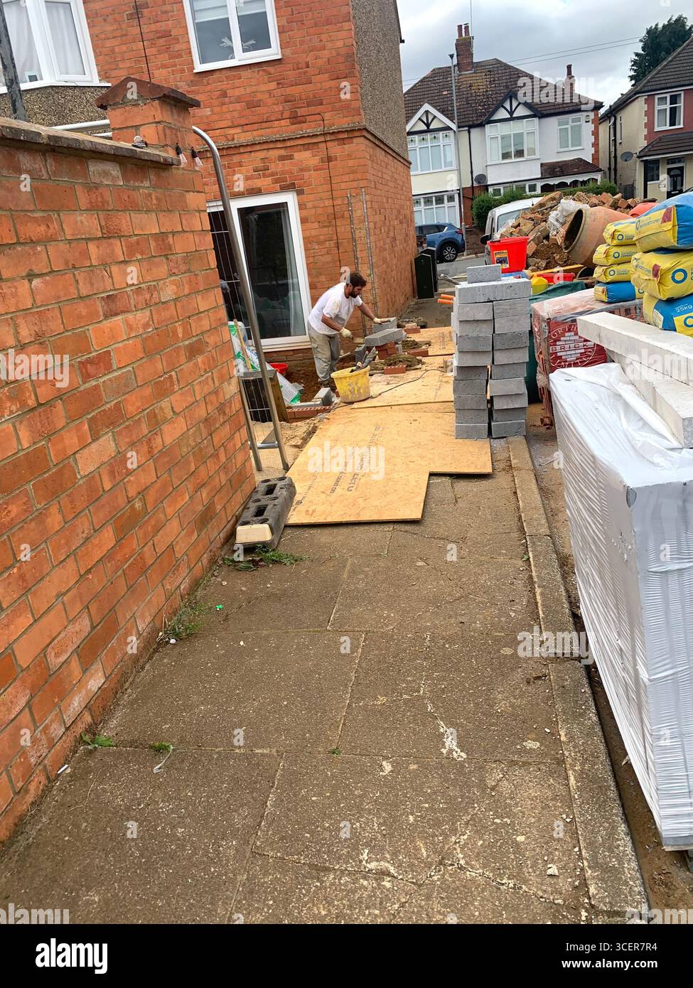 Builder building brick wall breeze blocks concrete street  house home contractor built old style type block paving style repair make new construction - Smartphone Captured Stock Image