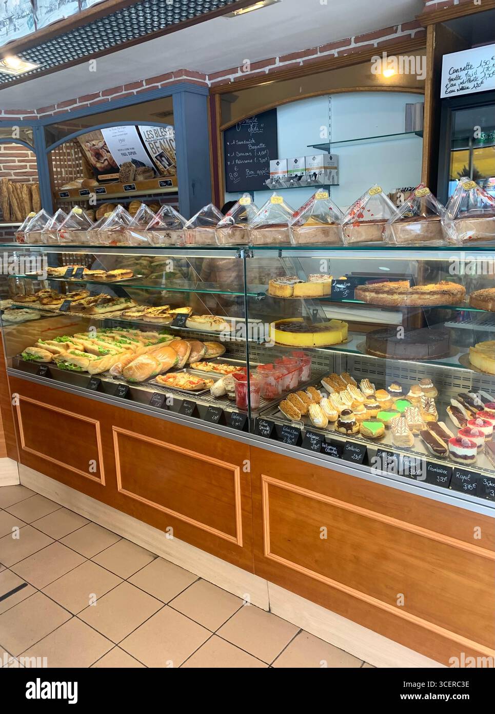 Vernon France shops shop tourists village town locals people cobbles cobbled restaurant eating food old style houses polar bear artwork sign signs - Smartphone Captured Stock Image