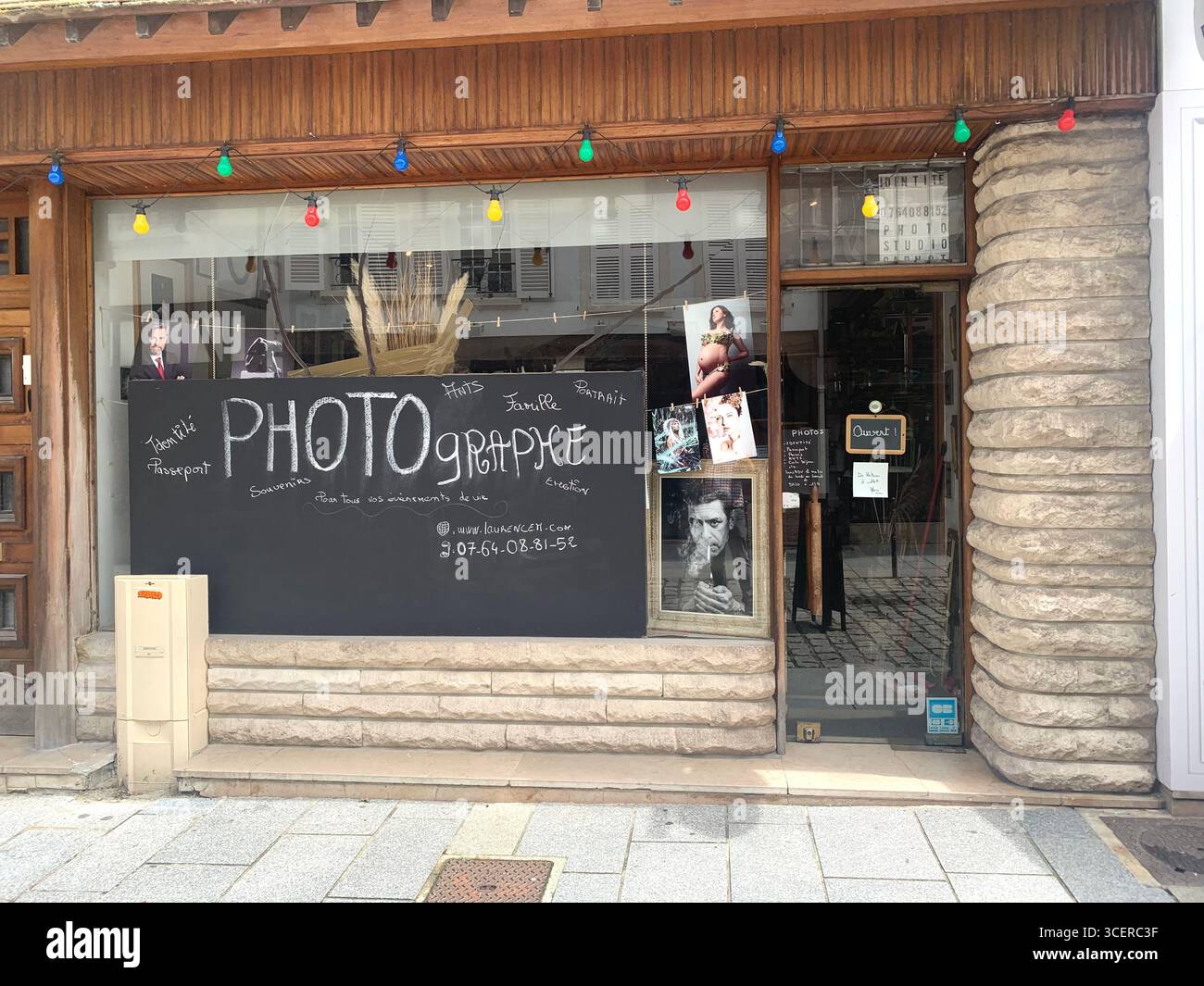 Vernon France shops shop tourists village town locals people cobbles cobbled restaurant eating food old style houses polar bear artwork sign signs - Smartphone Captured Stock Image