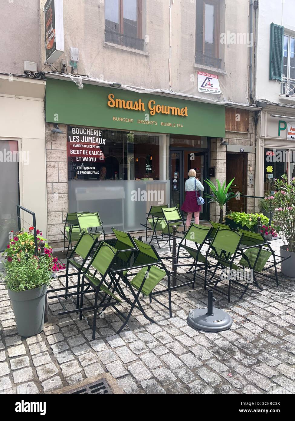 Vernon France shops shop tourists village town locals people cobbles cobbled restaurant eating food old style houses polar bear artwork sign signs - Smartphone Captured Stock Image