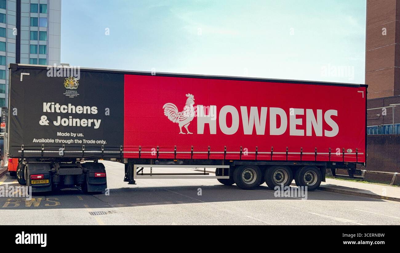 Cardiff, Wales, UK - 15 August 2025: Side view of an articulated lorry in Cardiff city centre delivering materials for Howdens kitchens - Smartphone Captured Stock Image Cardiff, Wales, UK - 15 August 2025: Side view of an articulated lorry in Cardiff city centre delivering materials for Howdens kitchens - Smartphone Captured Stock Image