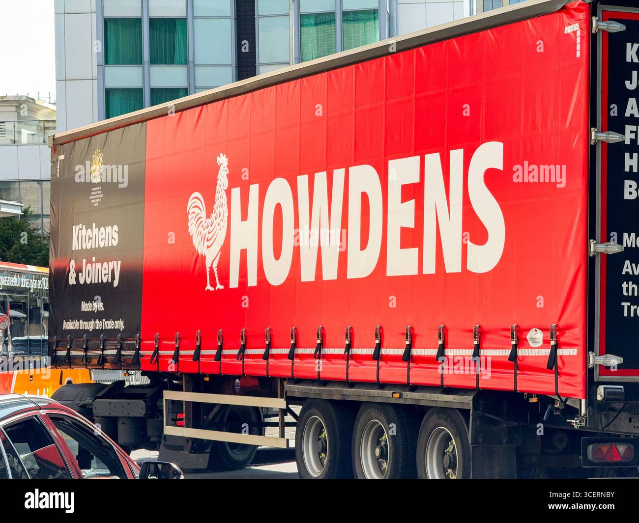 Cardiff, Wales, UK - 15 August 2025: Side view of an articulated lorry in Cardiff city centre delivering materials for Howdens kitchens - Smartphone Captured Stock Image Cardiff, Wales, UK - 15 August 2025: Side view of an articulated lorry in Cardiff city centre delivering materials for Howdens kitchens - Smartphone Captured Stock Image