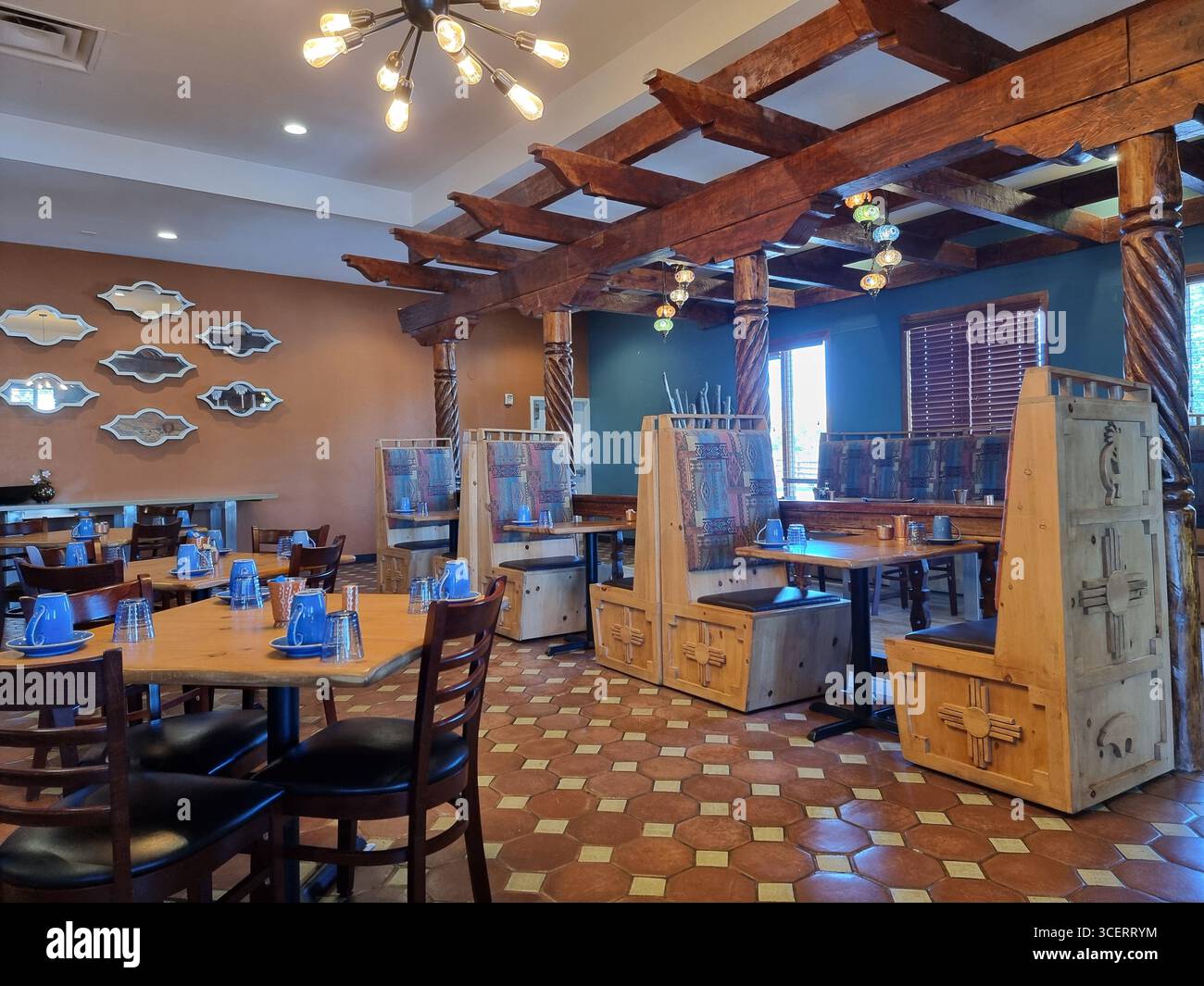 Interior of restaurant in New Mexican style at breakfast time; wooden tables, wooden chairs, booths with carved wood; pergola - Smartphone Captured Stock Image