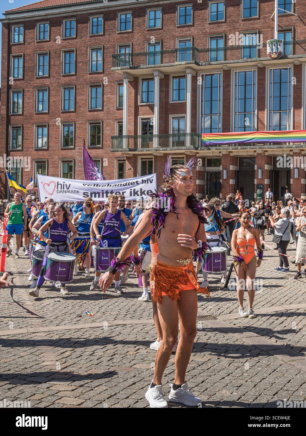 Copenhagen, August 16, 2025, Pride parade with male dancer in glitter costume and drummers celebrating love, diversity and equality Stock Photo