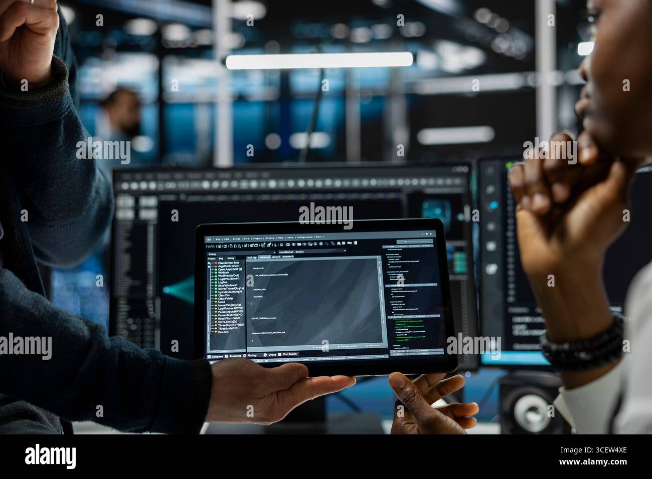 Close up of programmers coding on tablet in data center, refining algorithms for faster processing. IT workers using device in server room, conducting tests using software Stock Photo