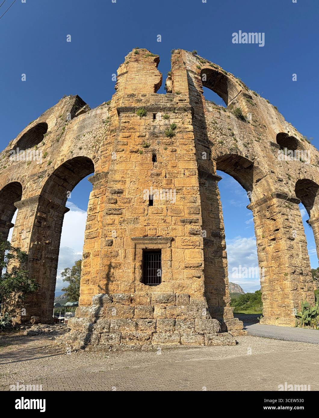Turkiye, Antalya, Aspendos Aqueduduct, The ancient Roman aqueduct of Aspendos in Turkey, preserved in a scenic rural landscape under a clear blue sky. - Smartphone Captured Stock Image