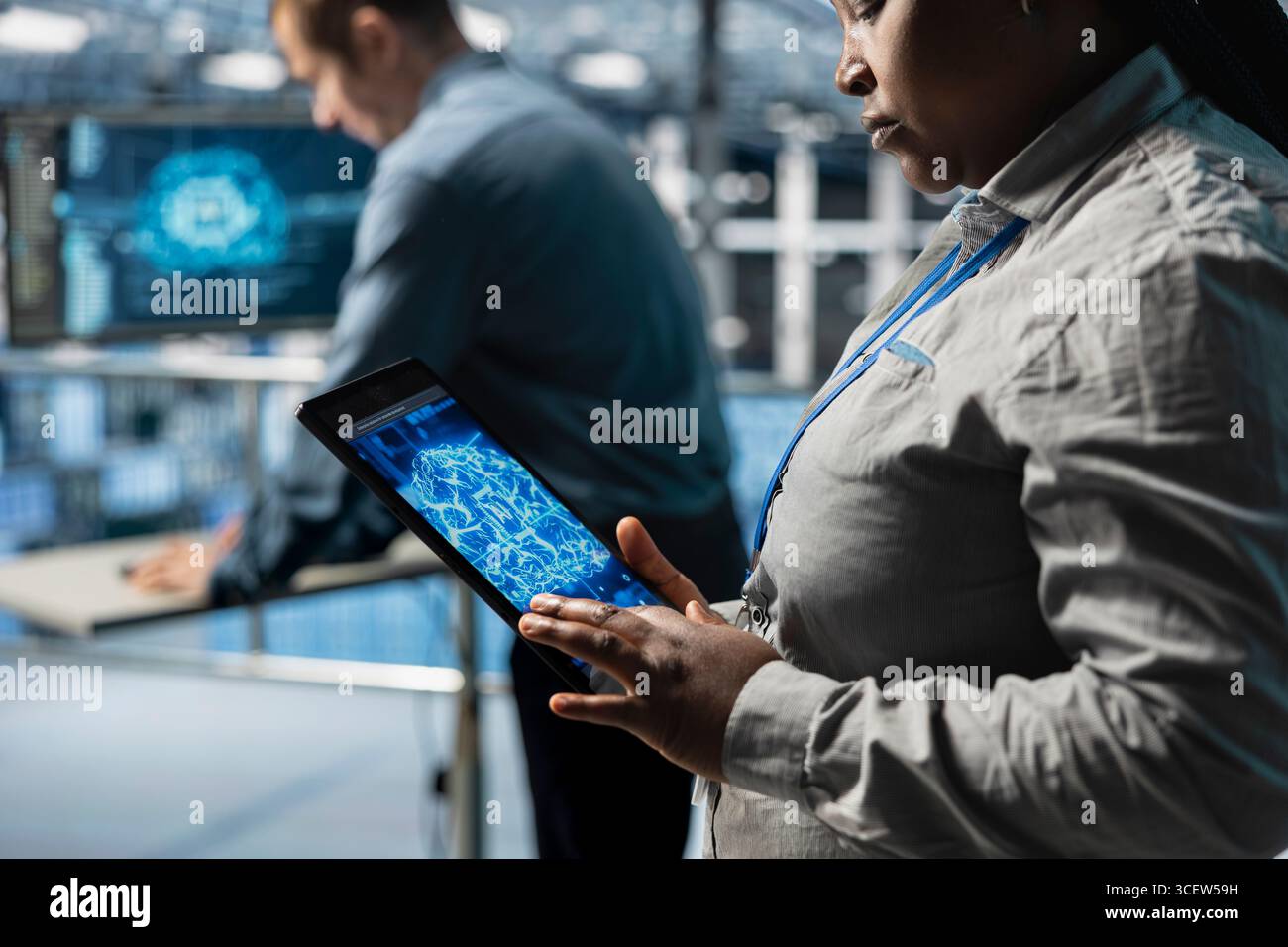 Close up of IT professional in server farm using tablet to improve AI system scalability for increased workloads. Data center engineer using device to adjust artificial intelligence model parameters Stock Photo