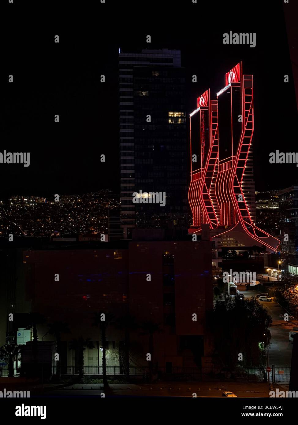 Turkey, Izmir 04/14/2025: Folkart towers. Night city. Bright lighting of buildings. Skyscrapers. Road, car headlights. Romantic night city - Smartphone Captured Stock Image