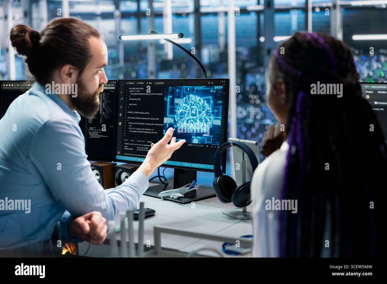 Data center programmers collaborating, working on neural networks AI databases. Server room colleagues talking, using machine learning artificial intelligence on PC to do algorithms improvements Stock Photo