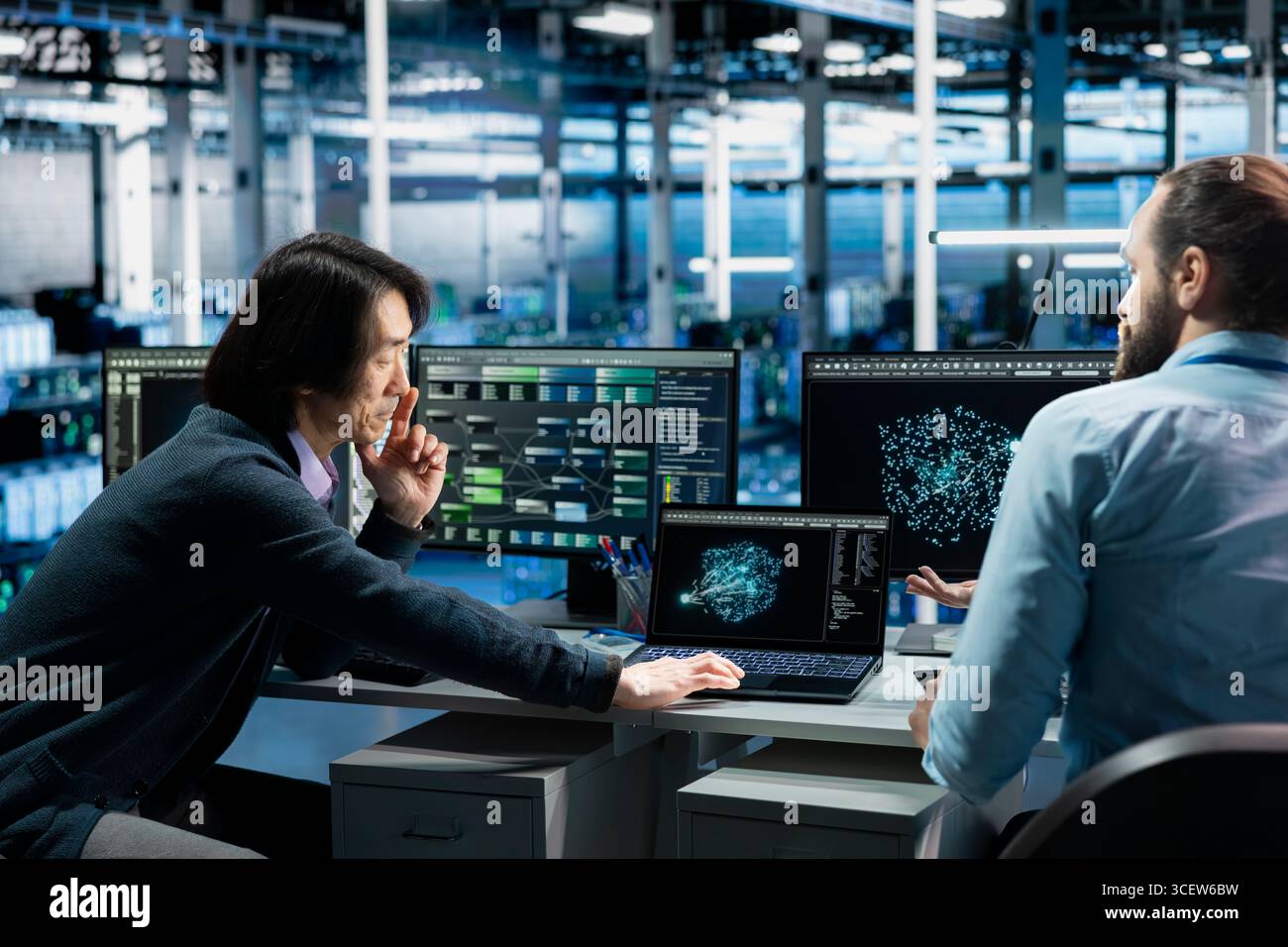 Software developers in data center troubleshooting server connectivity issues using AI. Asian man and technician in server room auditing systems for vulnerabilities using artificial intelligence Stock Photo