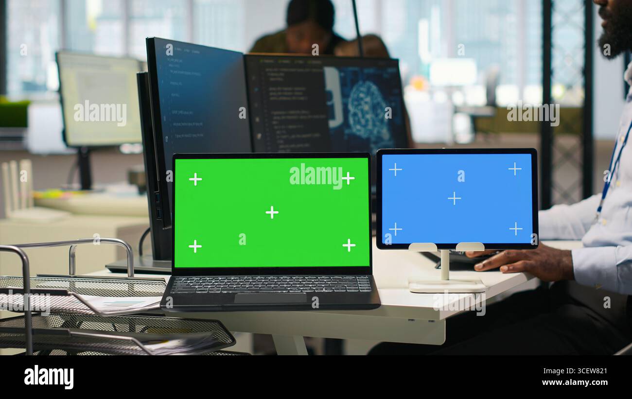 Software developer using AI on isolated screen laptop and tablet to optimize performance and forecast issues. IT expert in office training machine learning models using chroma key notebook, camera A Stock Photo