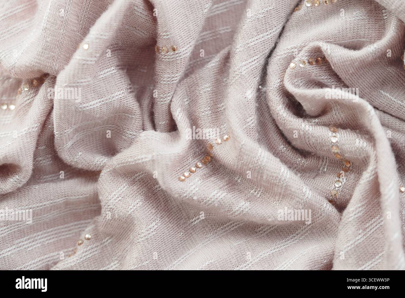 Soft pink fabric draped with delicate embellishments Stock Photo