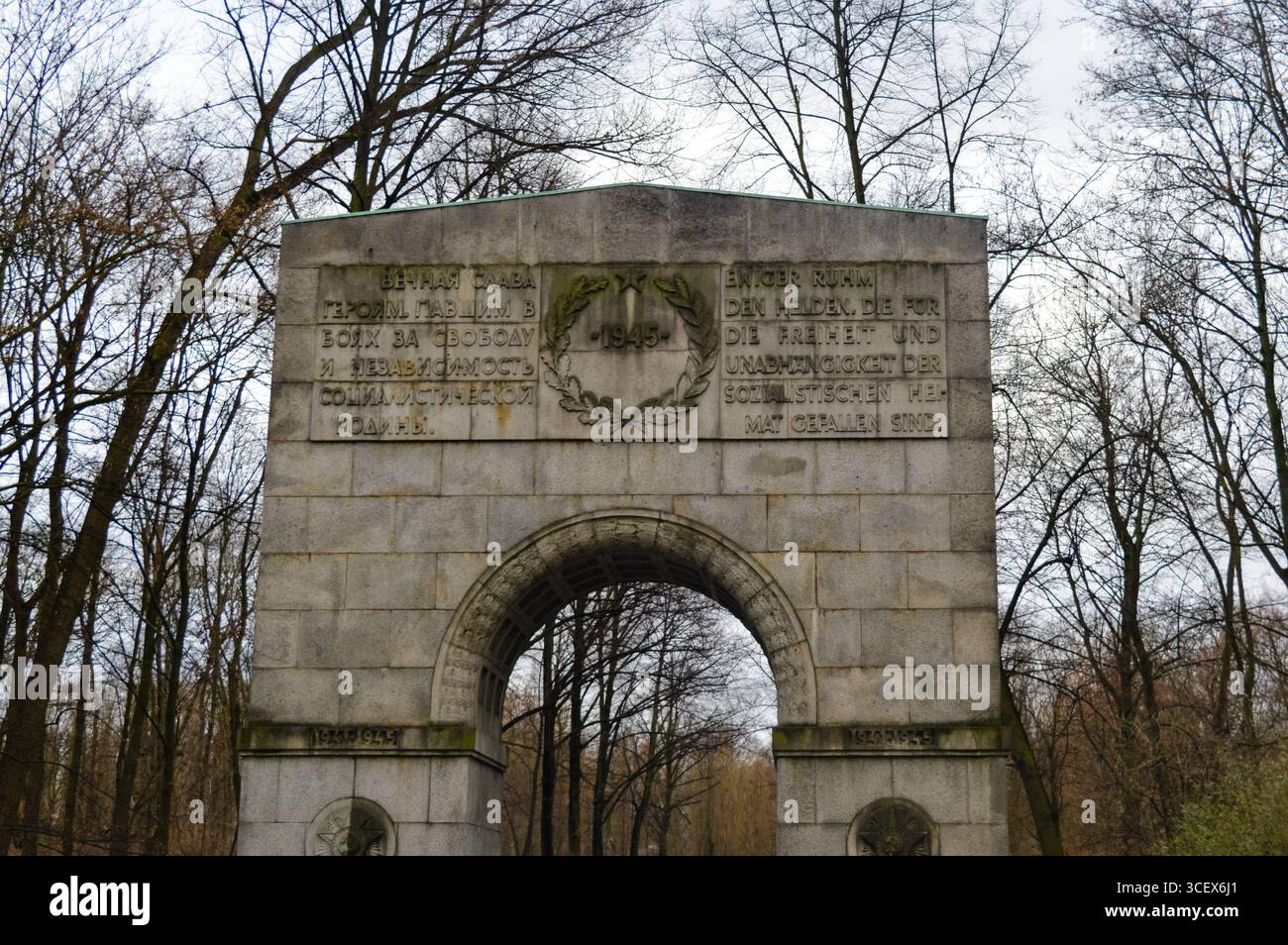 Stone arch with Russian and German inscriptions at the Soviet War Memorial in Treptower Park, Berlin, commemorating fallen World War II heroes. Stock Photo
