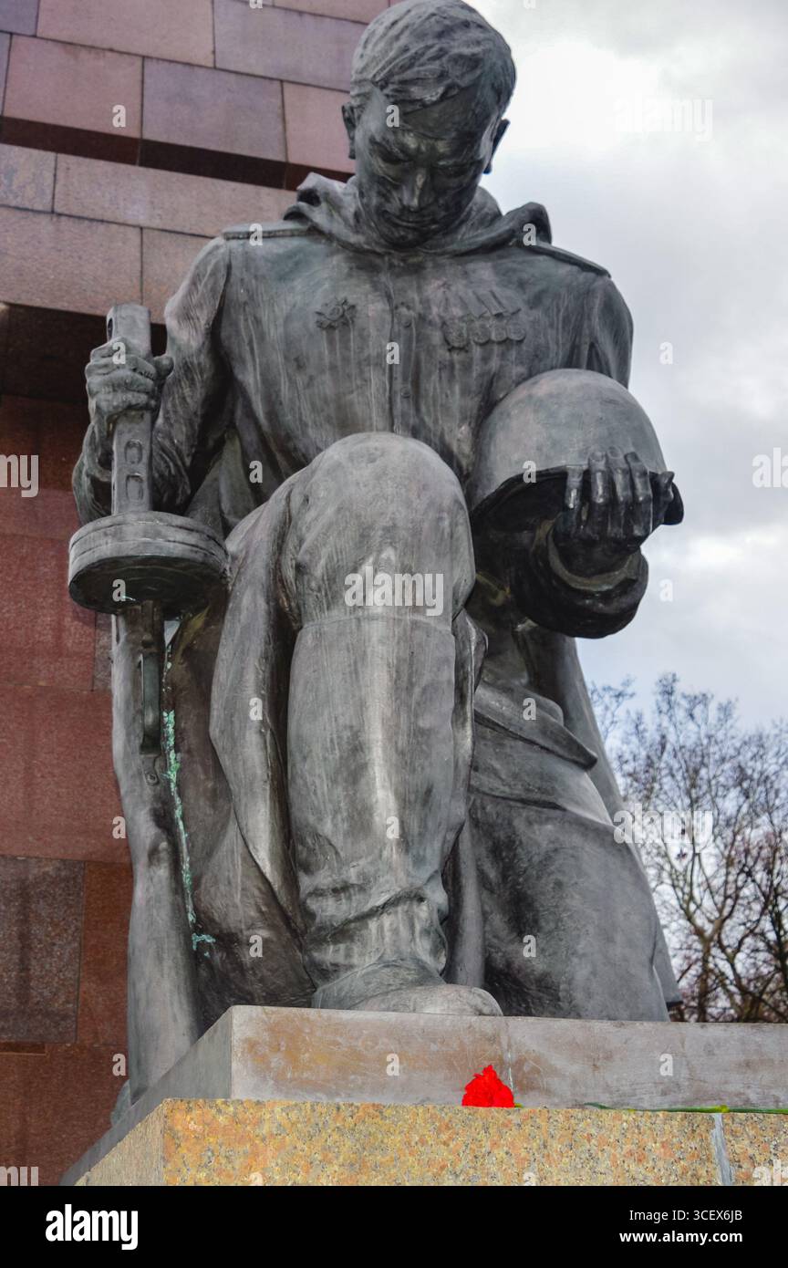 Soviet soldier statue at Treptower Park in Berlin, Germany, holding helmet and sword, serving as a solemn World War II war memorial. Stock Photo