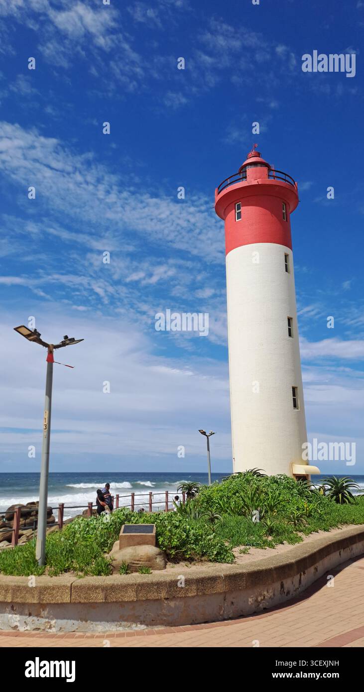 The red and white Umhlanga Lighthouse on the KwaZulu-Natal coast, South Africa, standing against a bright blue sky overlooking the Indian Ocean. - Smartphone Captured Stock Image