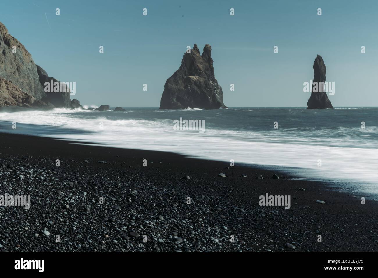 Dramatic black sand beaches and sea stacks at Reynisfjara, alongside a ...