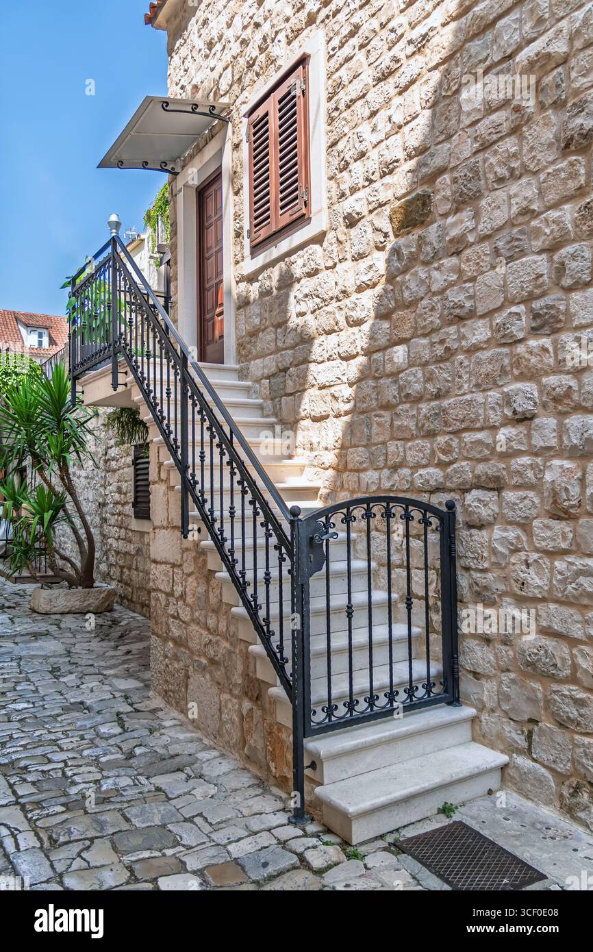 Beautiful stone staircase with an ornate wrought iron railing leading ...