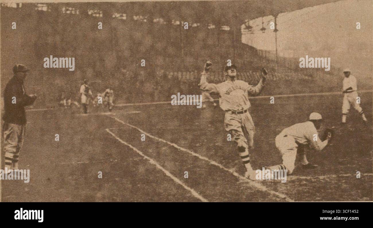On November 12, 1924, a moment during a baseball game between the Giants and the White Sox is captured, showing a runner reaching base at the same time the opposing player catches the ball. This is a dramatic moment during a key play. Stock Photo