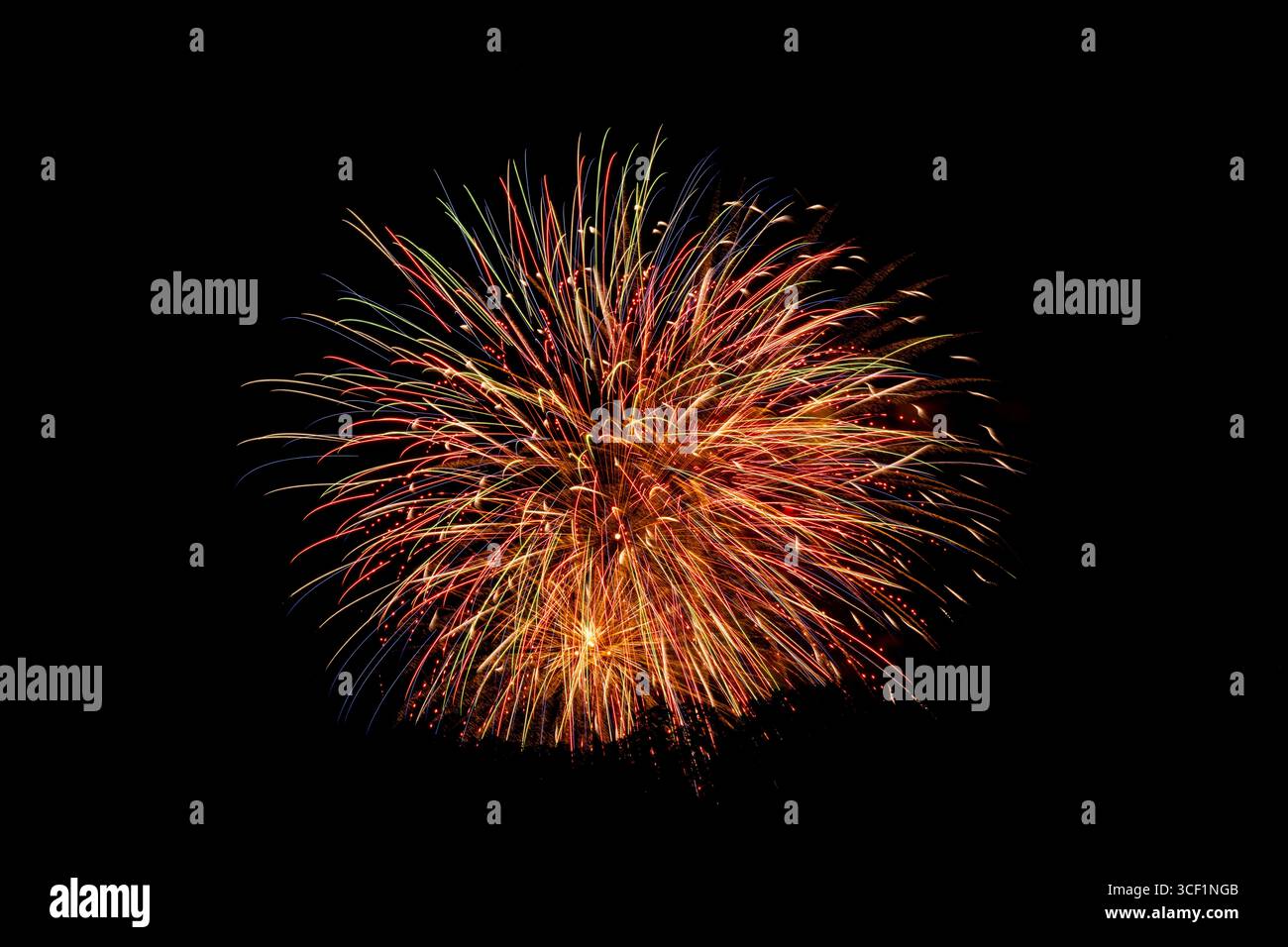 Multiple fireworks bursts captured against a dark sky Stock Photo