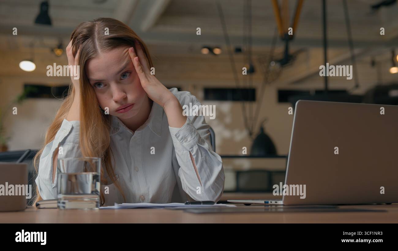 Frustrated Caucasian office female manager business woman girl review documents paperwork difficult job writing report businesswoman stack feeling Stock Photo