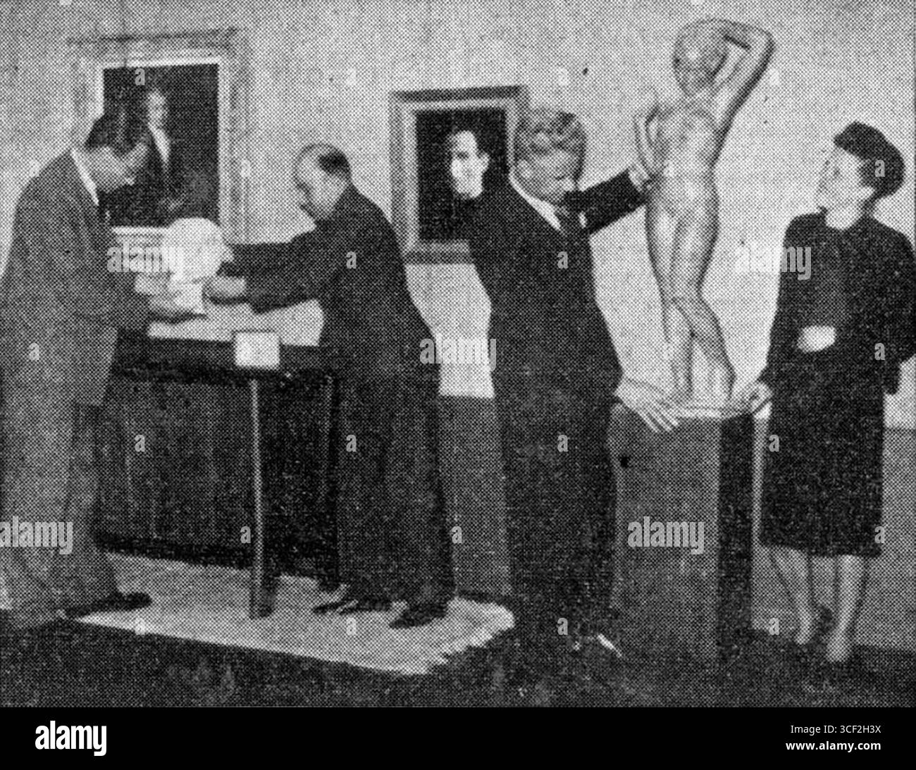 This photograph depicts the setup of an exhibition celebrating the 50th anniversary of the Haagsche Kunstkring at the Gemeentemuseum Den Haag in 1941. The people in the image include Chris de Moor, Jan van Heel, Jan Franken Pzn., and Corry Franzen-Heslenfeld. Stock Photo