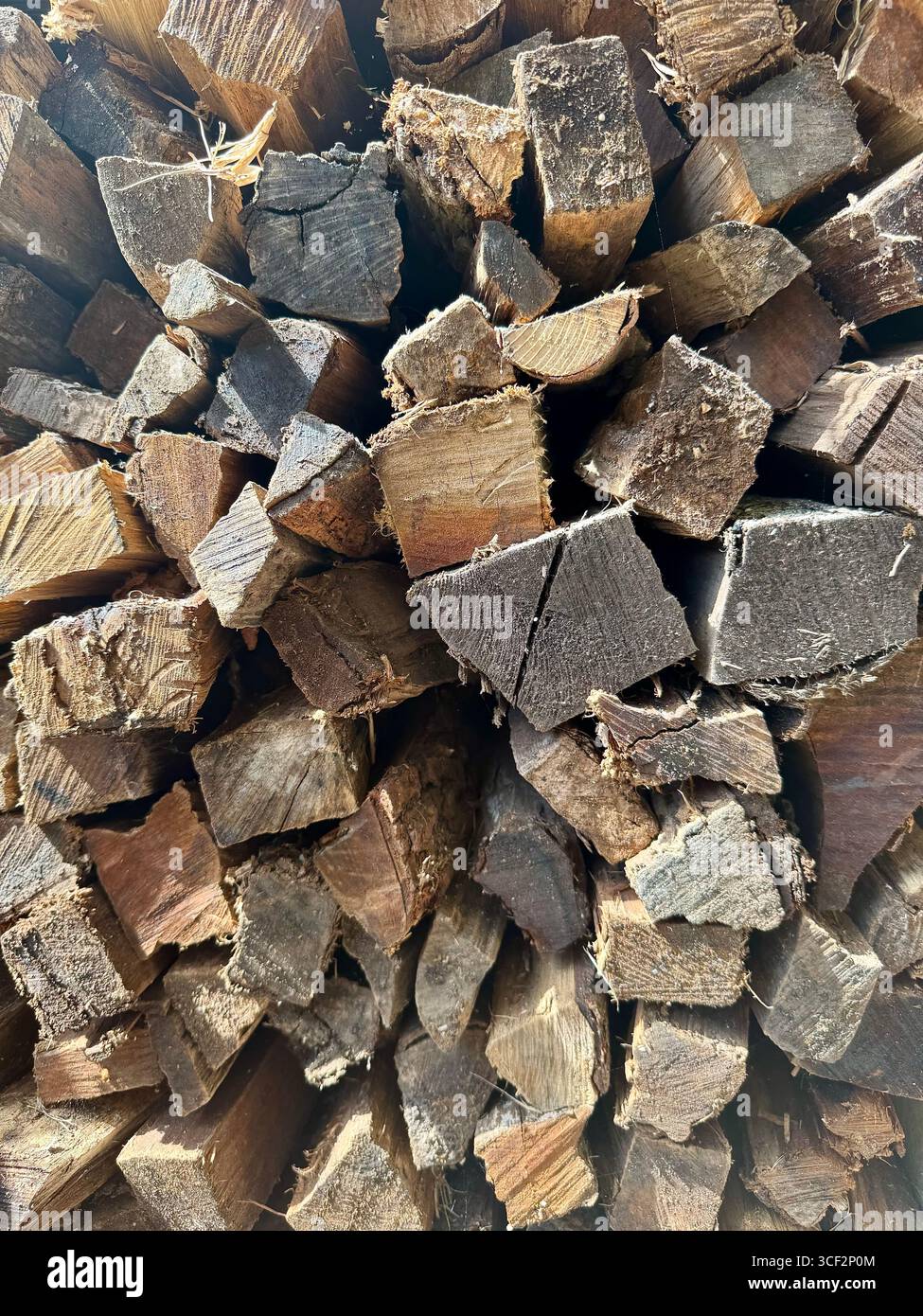 Stack of chopped firewood prepared for storage or use in a fireplace or wood-burning stove. - Smartphone Captured Stock Image