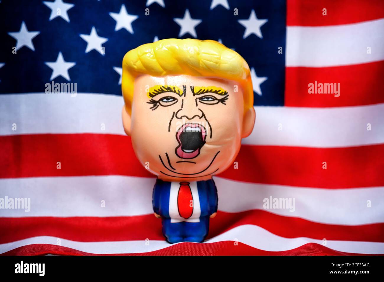 Rubber figure of US President Donald Trump in front of the USA flag ...