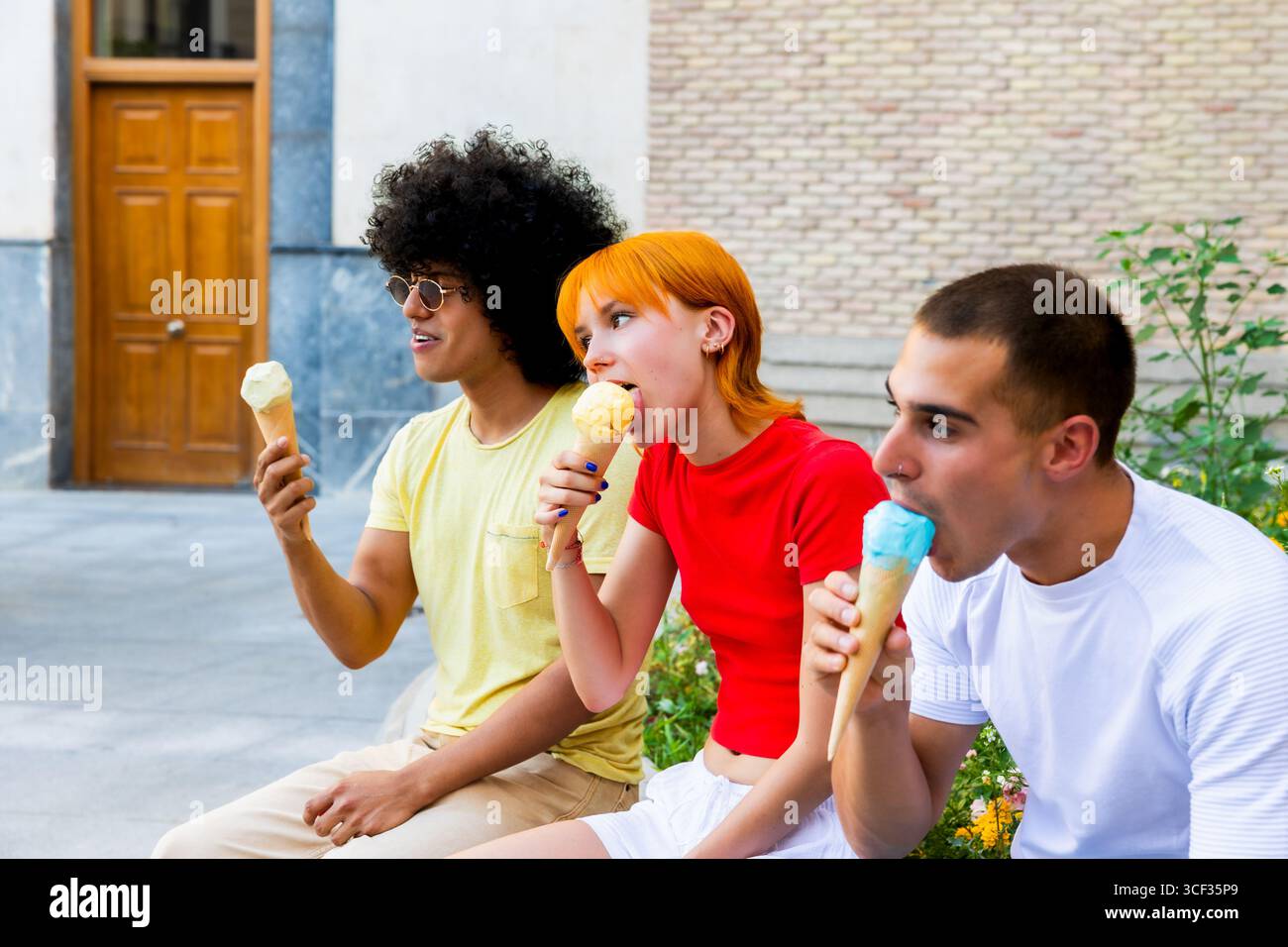 Three friends enjoying ice cream cones outdoors Stock Photo