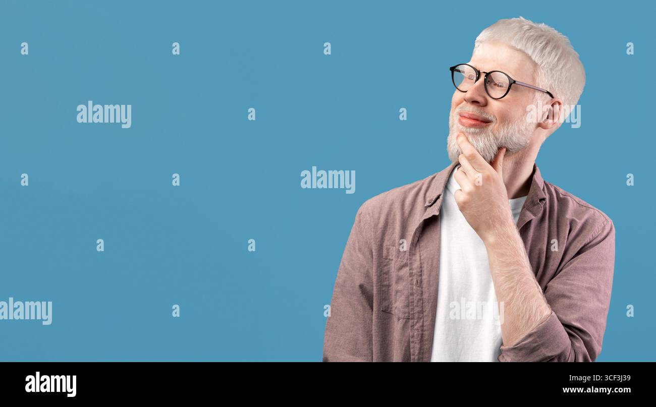 Pensive albino guy thinking over decision, looking at empty space over turquoise studio background Stock Photo