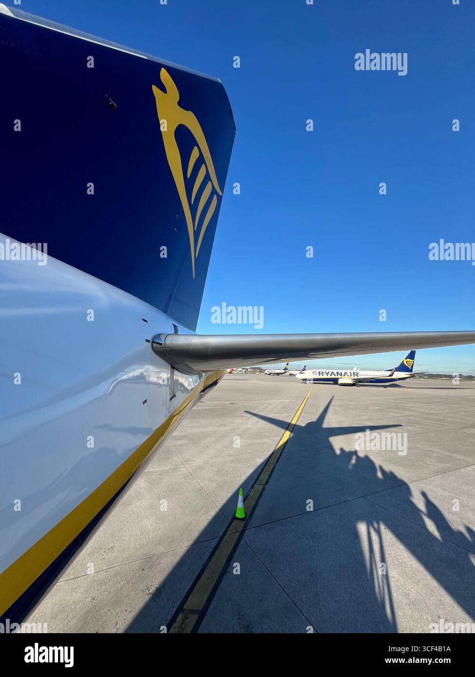 Ryanair aircraft on the tarmac with company logo and tail fin visible at an airport. - Smartphone Captured Stock Image