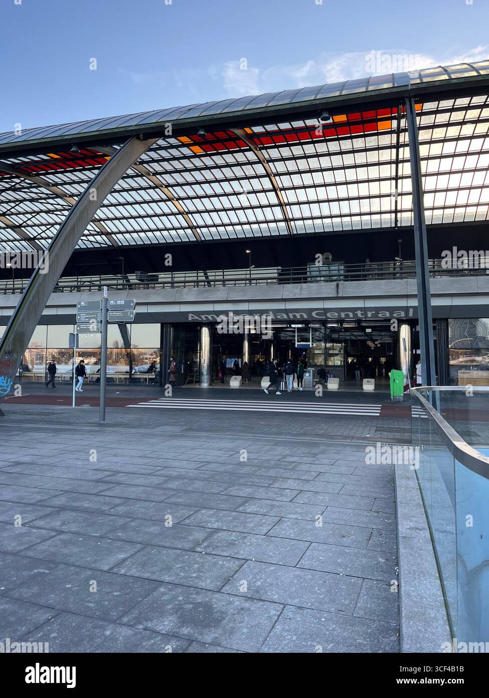 Modern station entrance with glass and steel architecture, people walking in the plaza. - Smartphone Captured Stock Image
