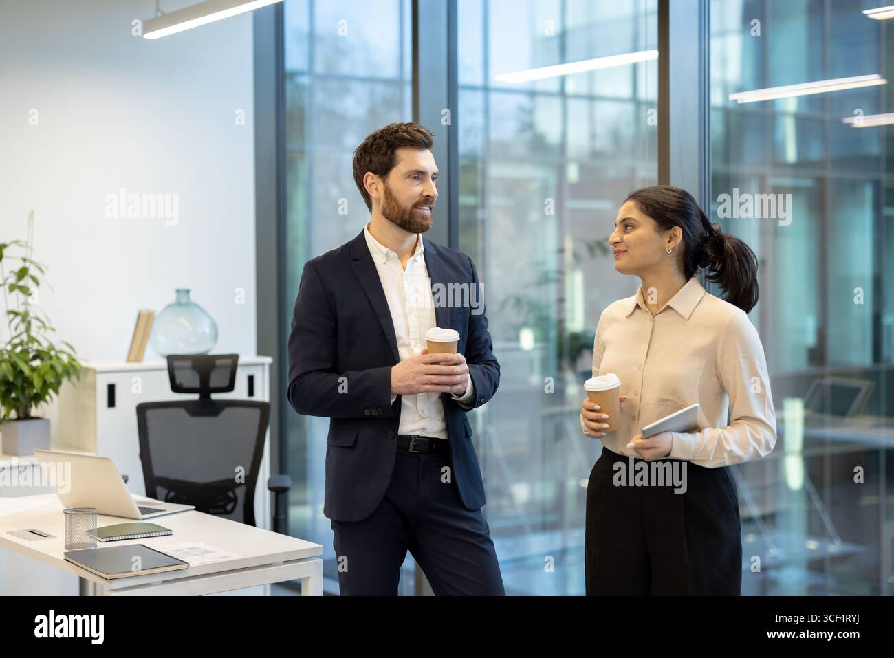 Professionals interacting in an office space, showcasing a collaborative work environment and professionalism. Stock Photo