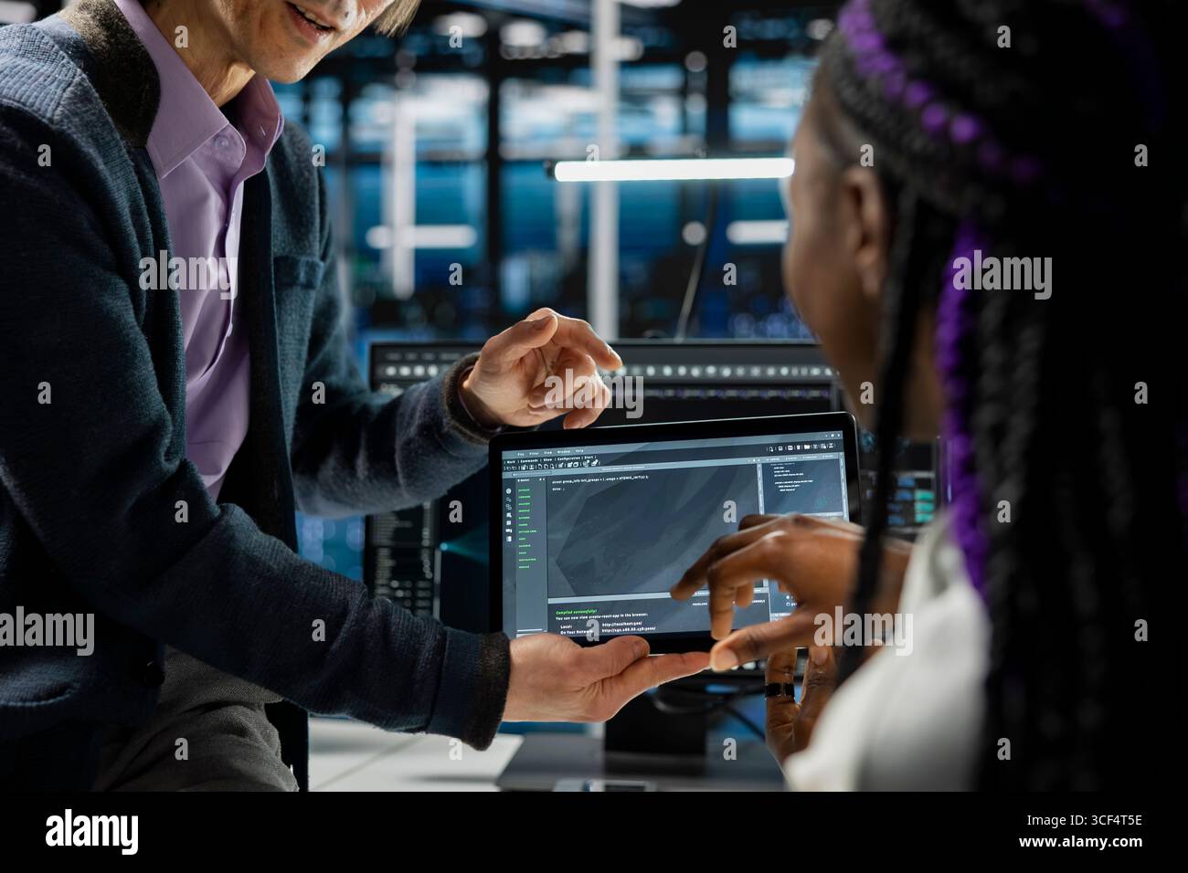 Close up of programmers coding on tablet in data center, updating AI driven automation scripts. IT workers using device in server room, programming artificial intelligence algorithms, debugging gear Stock Photo