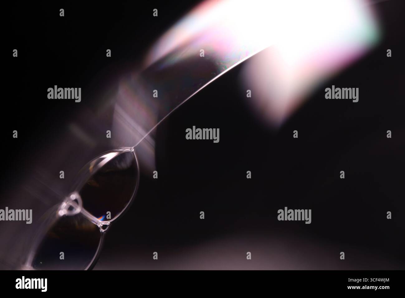 Abstract macro of sharp light refractions and iridescent soap bubbles with geometric prism effects on a dark background Stock Photo