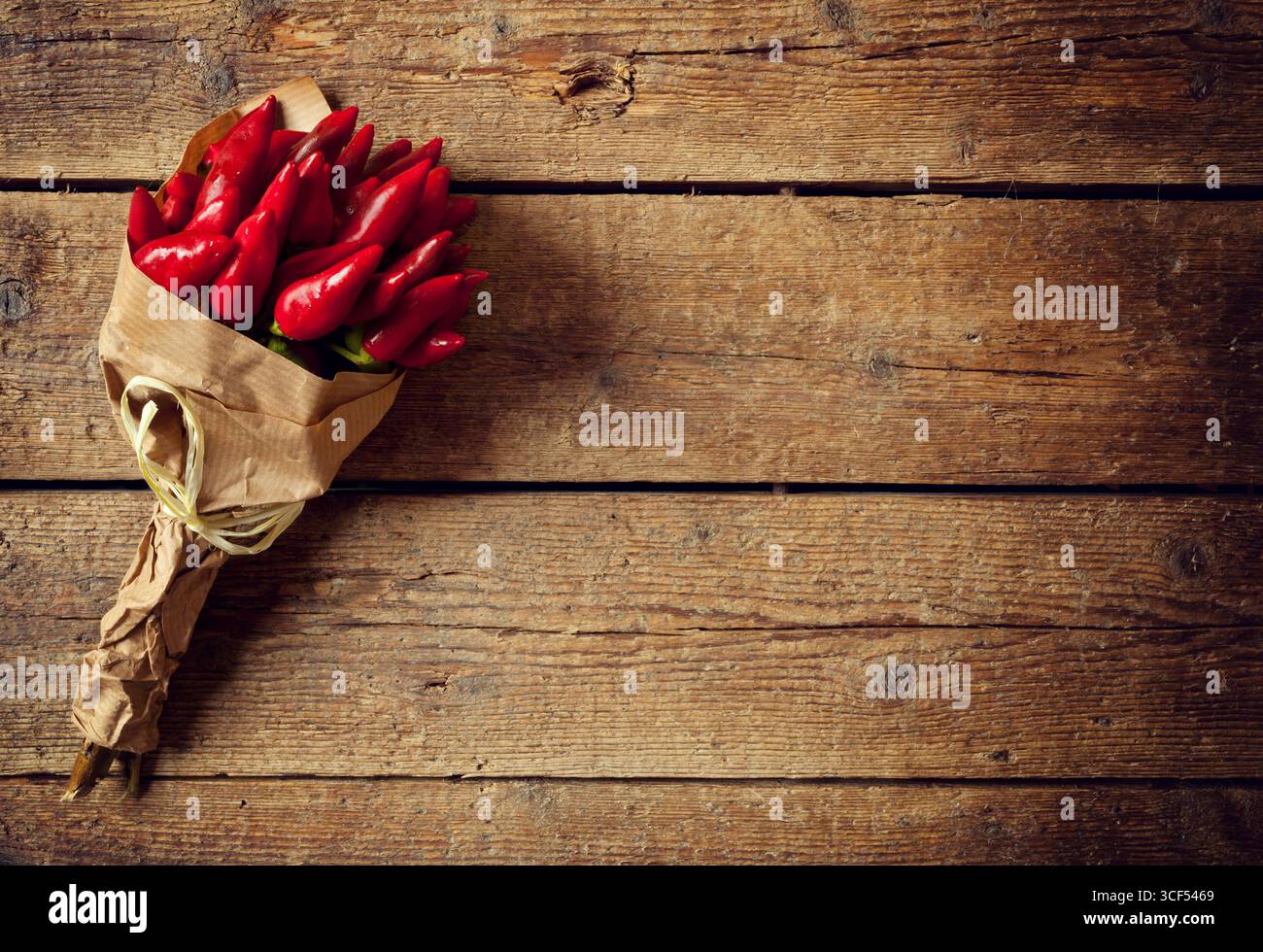 Bunch of fresh small red hot pepper on wooden table Stock Photo