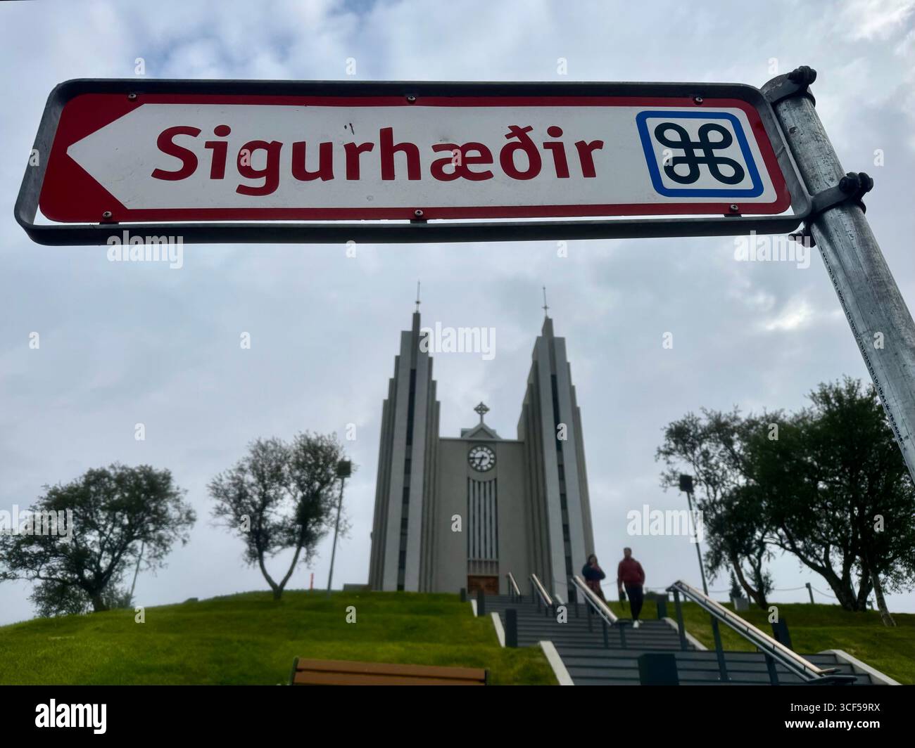 The Church of Akureyi dominates the top of the hill behind the sign for the Sigurhæðir Memorial House museum. - Smartphone Captured Stock Image