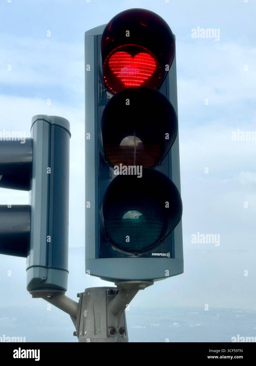 Closeup of the a lit up red heart-shaped traffic stop light in Akureyri. Stock Photo
