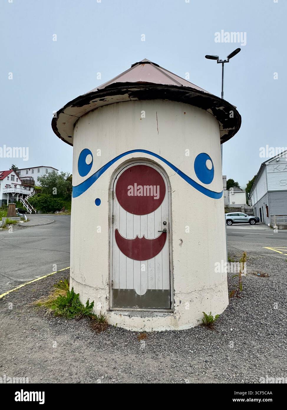Whimsically painted cylindrical building with a conical roof at the harbor in Husavik, Iceland. - Smartphone Captured Stock Image
