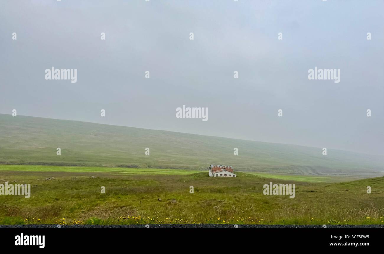 Lush green rolling hills of farm land and an old farm building in Hunathing vestra area of northwest Iceland in summertime. - Smartphone Captured Stock Image