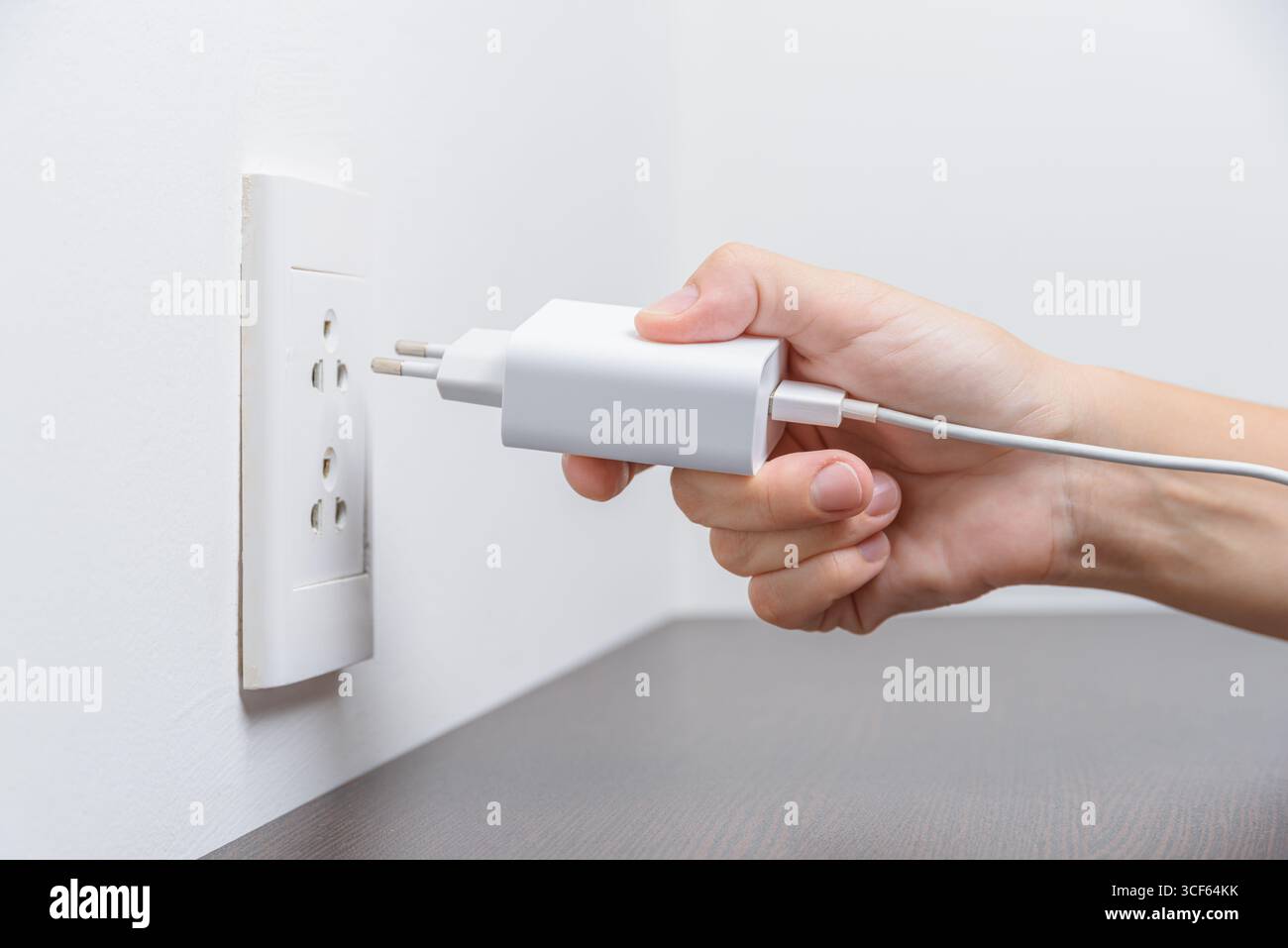 Putting Plug In Female hand inserting a white electrical plug into outlet Stock Photo ...