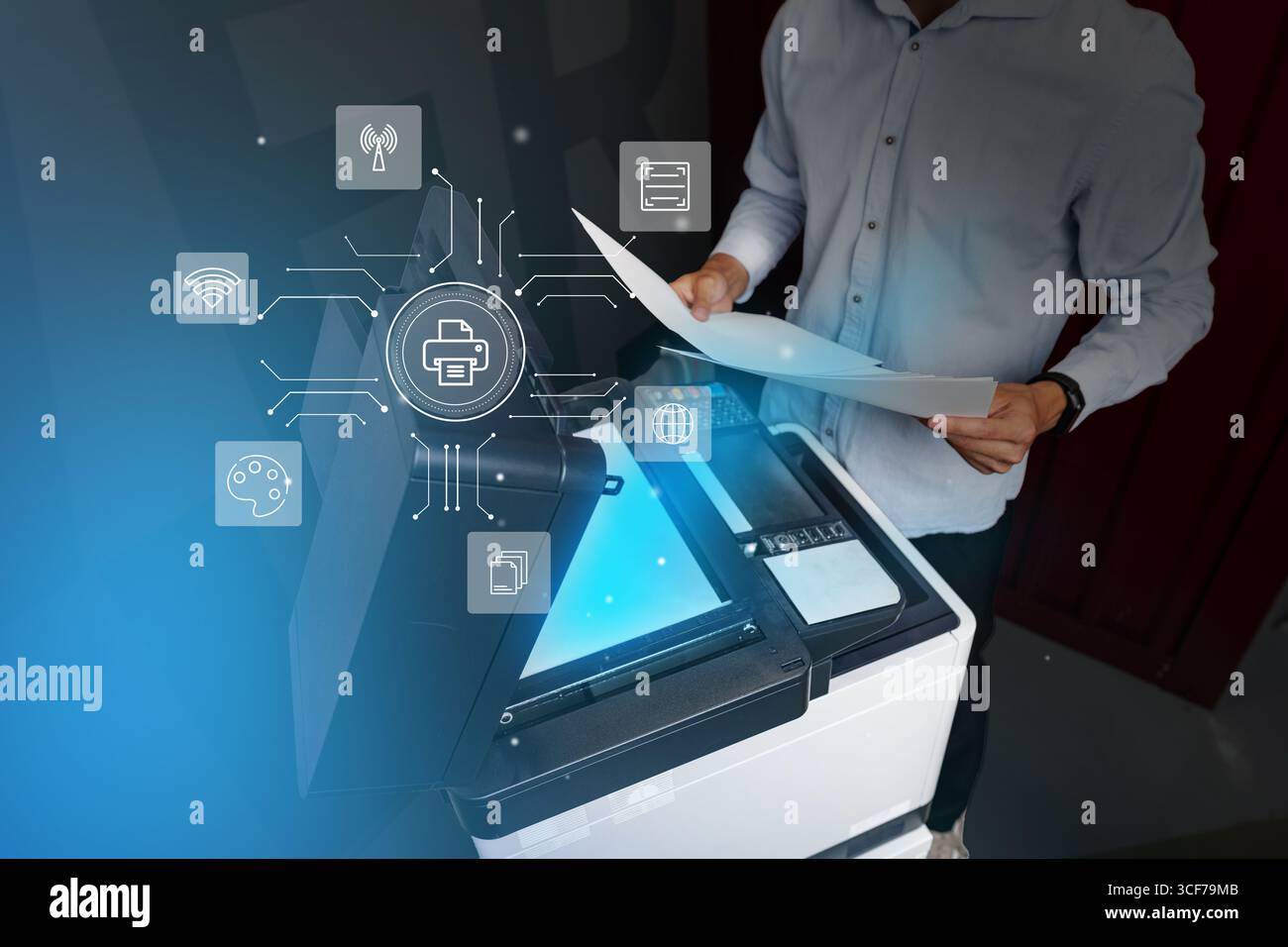 Man operates a multifunction printer in a modern office environment while using technology for document management Stock Photo