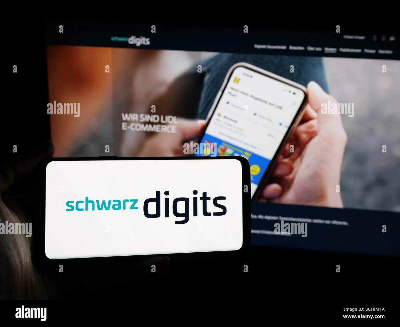 Stuttgart, Germany - 08-07-2025: Person holding smartphone with logo of German IT company Schwarz Digits KG on screen in front of website. Stock Photo