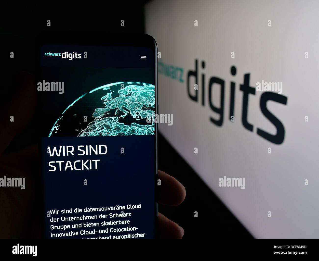 Stuttgart, Germany - 08-07-2025: Person holding cellphone with webpage of German IT company Schwarz Digits KG on screen in front of logo. Stock Photo