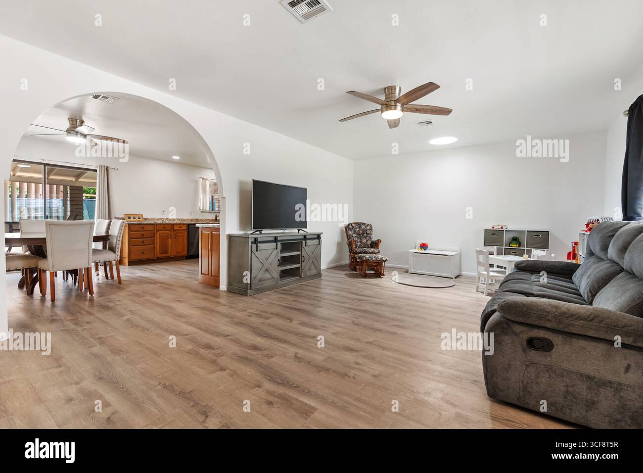 Bright and airy living room featuring an open layout, stylish furniture, and modern design elements. Perfect for relaxation and entertaining guests. Stock Photo