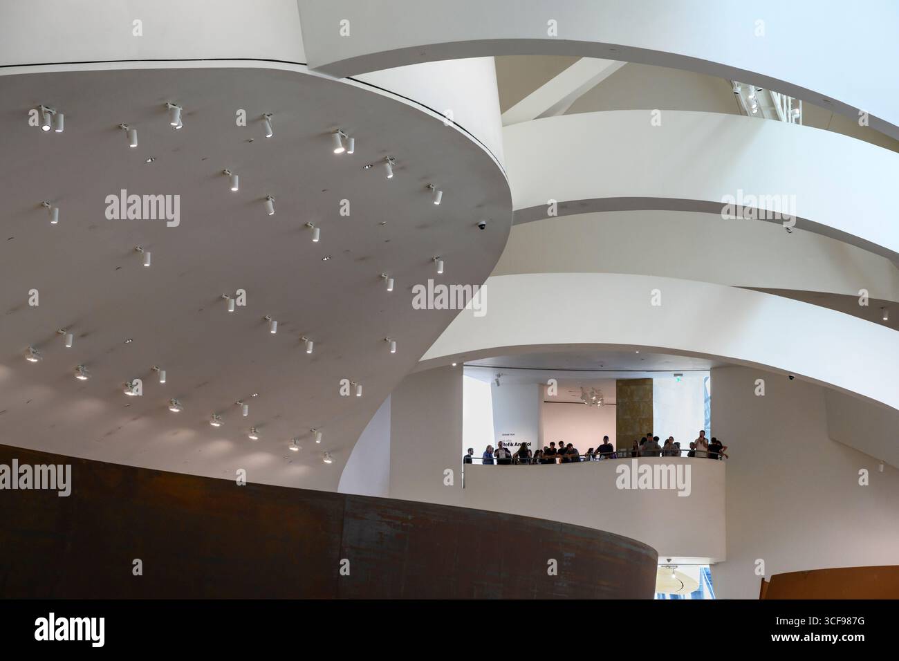 Visitors look down from an interior balcony in the  Guggenheim Museum in Bilbao, Northern Spain, Stock Photo